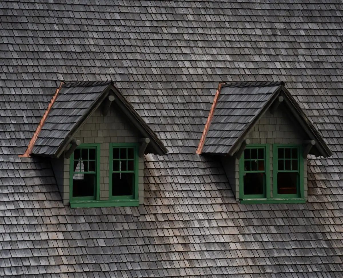 Dormers on a shingle roof in Costa Mesa, CA, where step flashing and kickout flashing carry water past the walls